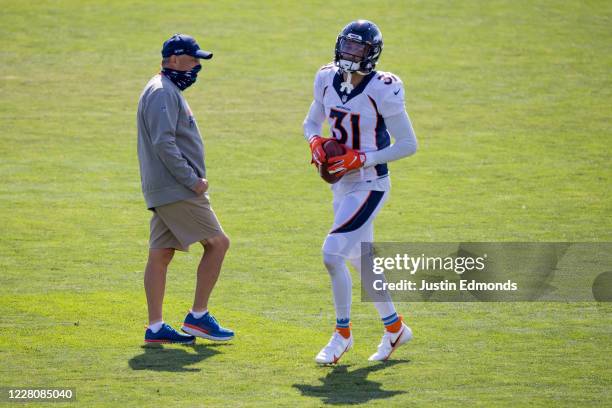 Safety Justin Simmons of the Denver Broncos jogs near head coach Vic Fangio of the Denver Broncos during a training session at UCHealth Training...