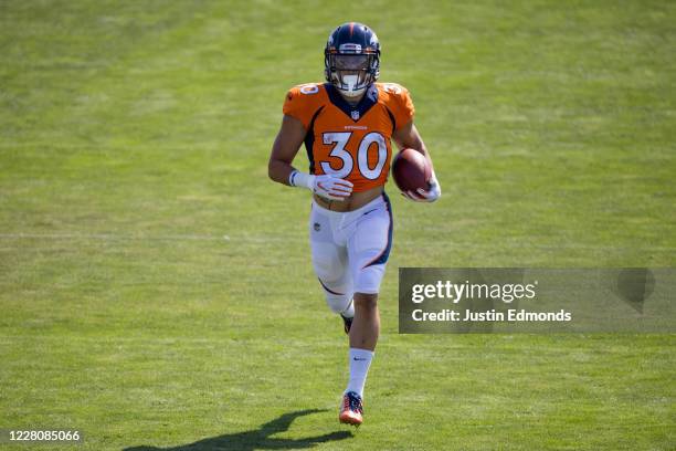 Running back Phillip Lindsay of the Denver Broncos runs with the football during a training session at UCHealth Training Center on August 17, 2020 in...