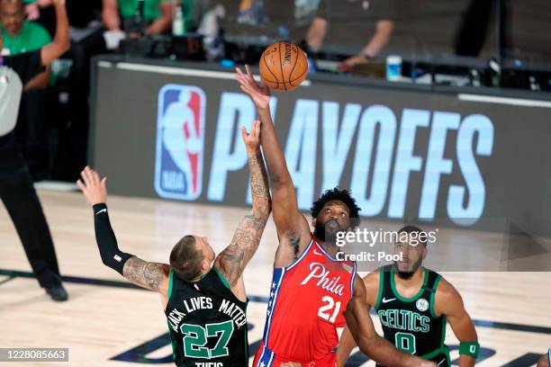 Joel Embiid of the Philadelphia 76ers and Daniel Theis of the Boston Celtics compete for the tip-off to start the first half at The Field House at...