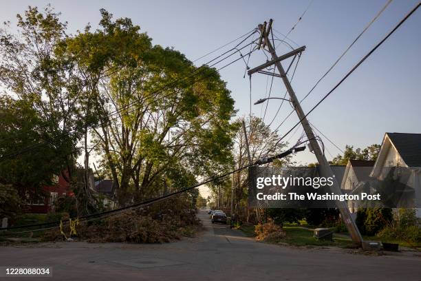 Downed power line leans over a street in Cedar Rapids, Iowa on Sunday, August 16, 2020. A rare Derecho storm battered large sections of Cedar Rapids...