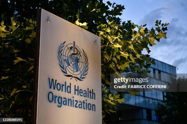 Photo taken in the late hours of August 17, 2020 shows a sign of the World Health Organization at their headquarters in Geneva amid the COVID-19...