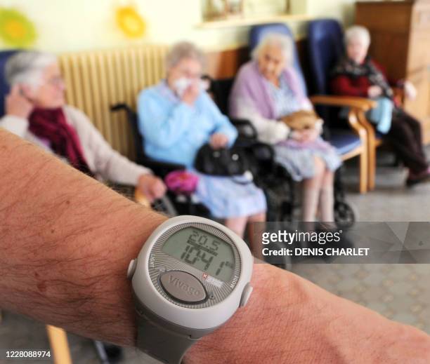 Surveillance par bracelet électronique dans une maison de retraite de Lille"- Un personne tient, le 20 mai 2009 un bracelet-montre électronique, dans...