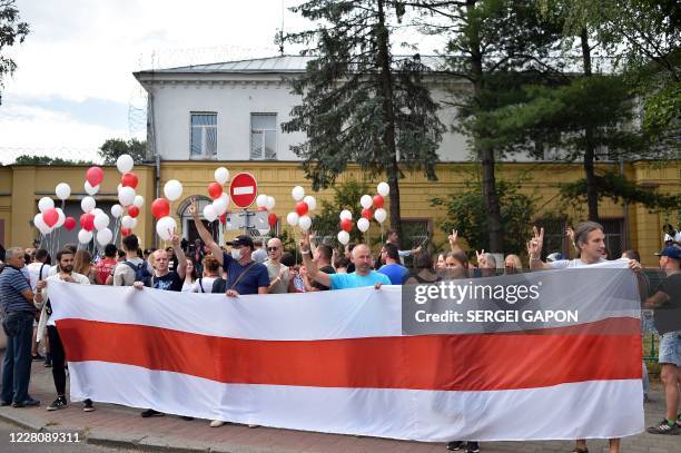 Opposition supporters holding white and red balloons and a former white-red-white flag of Belarus gather outside a pre-trial detention centre, where...