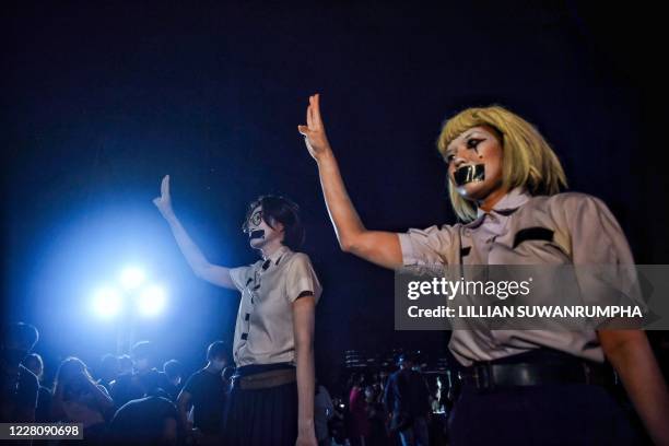 Students flash the three-fingered Hunger Games salute at an anti-government rally at Mahidol University in Nakhon Pathom on August 18, 2020. - The...