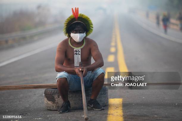 Member of the Kayapo tribe sits after they blocked highway BR163 during a protest on the outskirts of Novo Progresso in Para State, Brazil, on August...