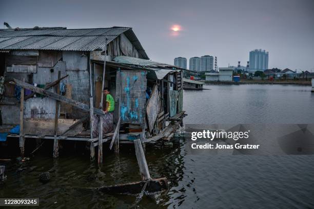 Stilt house surrounded by seawater in Jakarta. Jakarta is subsiding at record rates, thanks to decades of unfettered and illegal draining of the...