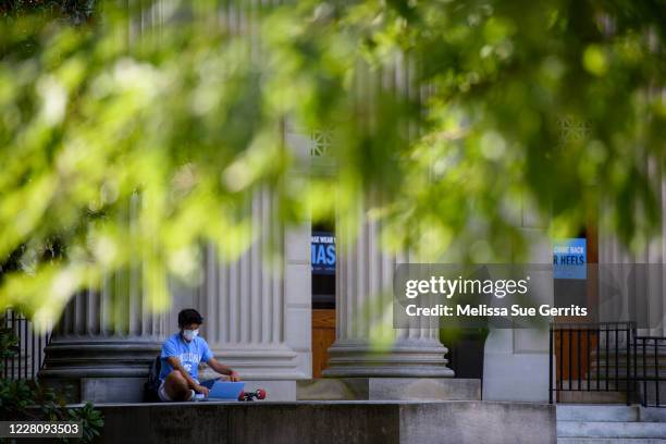 Student studies outside the closed Wilson Library on the campus of the University of North Carolina at Chapel Hill on August 18, 2020 in Chapel Hill,...