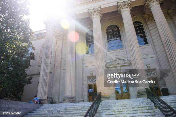 Student studies outside the closed Wilson Library on the campus of the University of North Carolina at Chapel Hill on August 18, 2020 in Chapel Hill,...