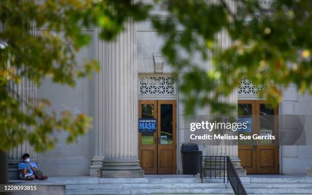 Student studies outside the closed Wilson Library on the campus of the University of North Carolina at Chapel Hill on August 18, 2020 in Chapel Hill,...