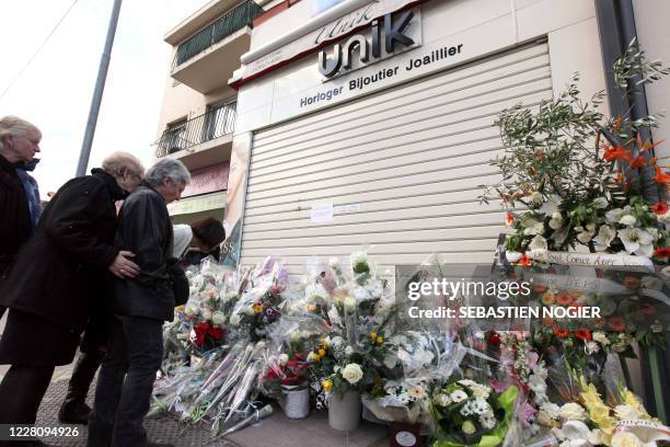 Des personnes déposent des fleurs devant la bijouterie de Thierry Unik, le 01 décembre 2011 à Cannes, lors d'une marche blanche en mémoire de ce...