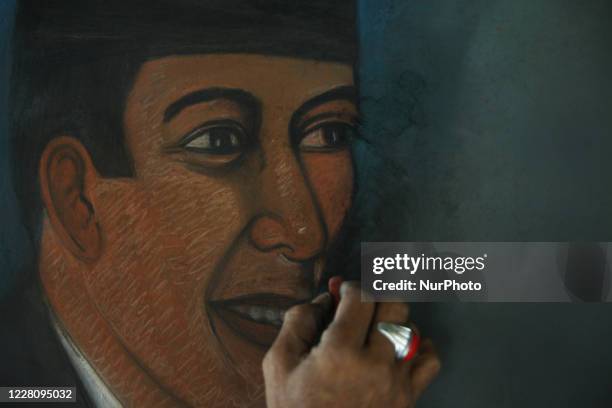 Bambang continue to paint a potrait of the Indonesian Founding Father, Sukarno at his street paint studio during the celebration of Indonesia's 75th...