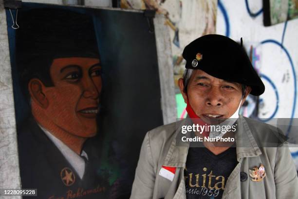 Bambang pose for potrait photograph next to his Sukarno paint at his street paint studio during the celebration of Indonesia's 75th Independence Day...