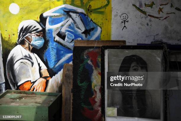 Bambang's paintings are displayed on the wall in his street paint studio during the celebration of Indonesia's 75th Independence Day in Jakarta,...