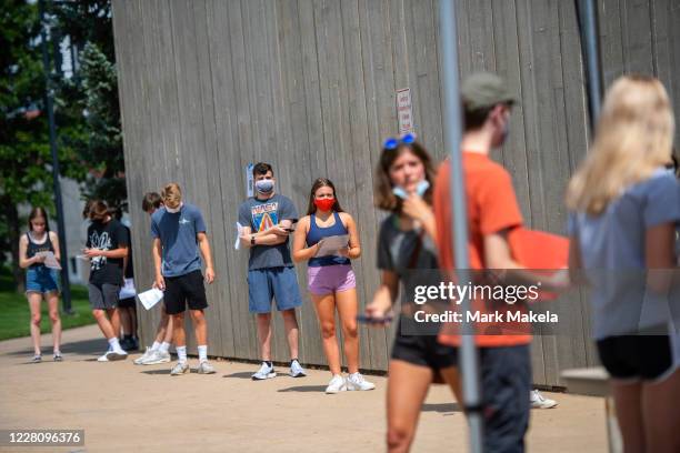 Students wait in line for registration and an identifying wristband after receiving a negative test result for coronavirus while arriving on campus...