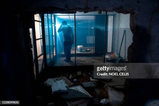 This photo taken on August 13, 2020 shows snake farmer Li Weiguo inside a cage for snakes at the back of his house in in Zhuzhou in central China's...