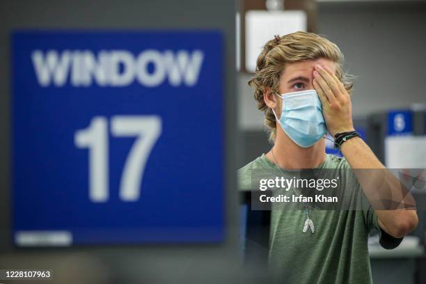 Bryce Hadfield gives an eye test for a driving license at DMV on Thursday, Aug. 13, 2020 in Westminster, CA.