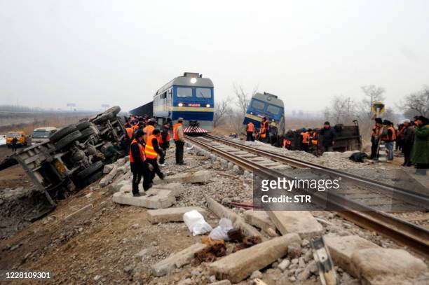 Workers clear the crash site after a freight train was derailed in a collision with a truck in Tianjin on February 26, 2011. China would continue to...