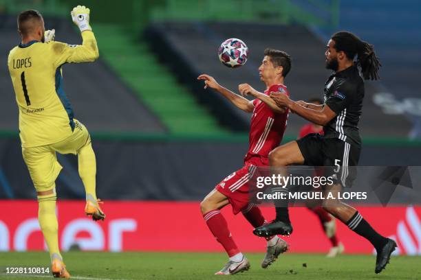 Lyon's Portuguese goalkeeper Anthony Lopes and Lyon's Belgian defender Jason Denayer challenge Bayern Munich's Polish forward Robert Lewandowski...