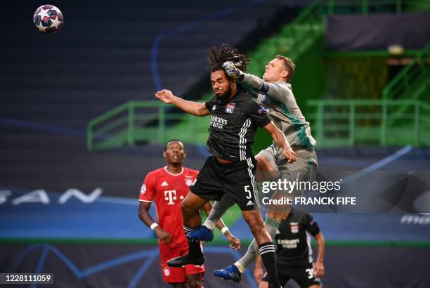 Bayern Munich's German goalkeeper Manuel Neuer punches the ball away as Lyon's Belgian defender Jason Denayer jumps for a header during the UEFA...