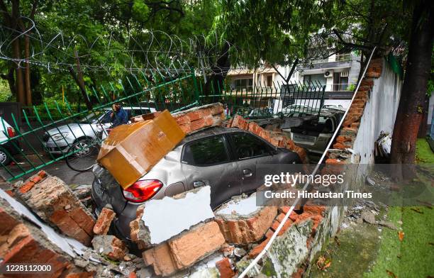 Car under the rubbles of a school boundary wall as it collapsed after heavy rain at Saket on August 19, 2020 in New Delhi, India. At least seven...