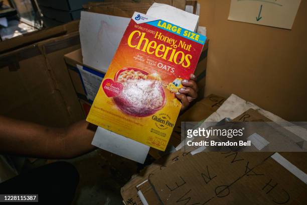 Jeanelle Austin holds up a sign, made out of a Cheerios box, at the Midwest Art Conservation Center on August 19, 2020 in Minneapolis, Minnesota....