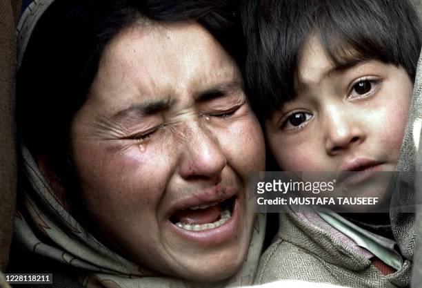 Kashmiri Muslim woman holds her son as she grieves for a relative killed in a blast in the village of Sangrama Pattan, some 30kms north of Srinagar,...