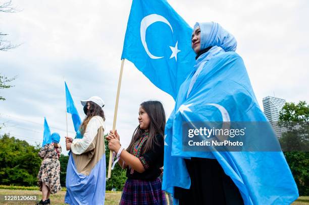 Woman and her daughter are holding Uyghur flags, during the demonstration 'Freedom for Uyghurs' in The Hague, Netherlands on August 20th, 2020.