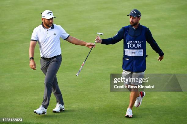 Jordan Smith of England hands his putter to his caddie on the 18th green during Day One of the Wales Open at the Celtic Manor Resort on August 20,...