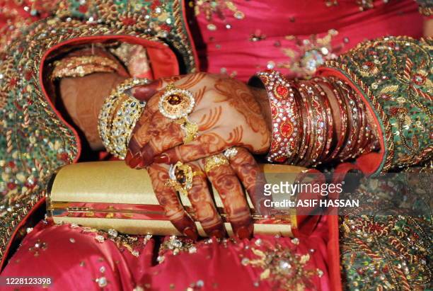Pakistan-society-economy-weddings,FOCUS by Hasan Mansoor A Pakistani bride folds her hands decorated with henna and jewellery at her wedding party in...