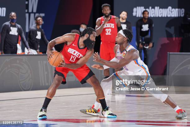Orlando, FL James Harden of the Houston Rockets handles the ball while Luguentz Dort of the Oklahoma City Thunder plays defense during Round One,...