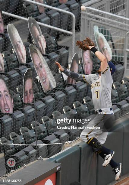 Eric Sogard of the Milwaukee Brewers catches a foul ball hit by Ehire Adrianza of the Minnesota Twins against the fan netting during the fourth...