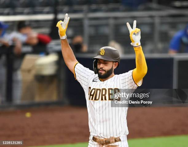 Eric Hosmer of the San Diego Padres points skyward after hitting a grand slam during the fifth nning of a baseball game against the Texas Rangers at...