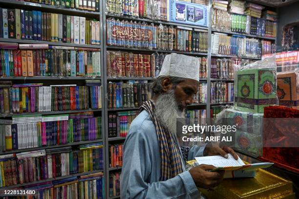 In this photograph taken on August 13 a customer checks a religious book at a store in Lahore. - At the centre of Pakistan's vibrant literary scene,...