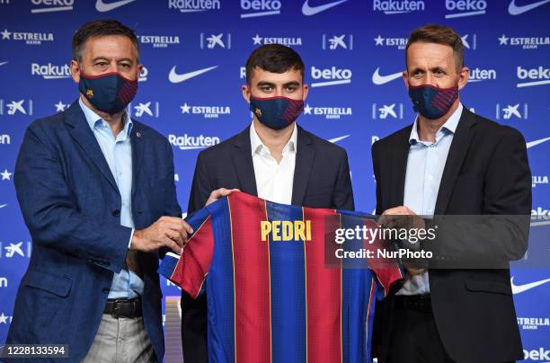 Josep Maria Bartomeu, Pedro Gonzalez Lopez - 'Pedri' and Ramon Planes poses for the media during Pedro Gonzalez Lopez - 'Pedri' unveiling at Camp Nou...