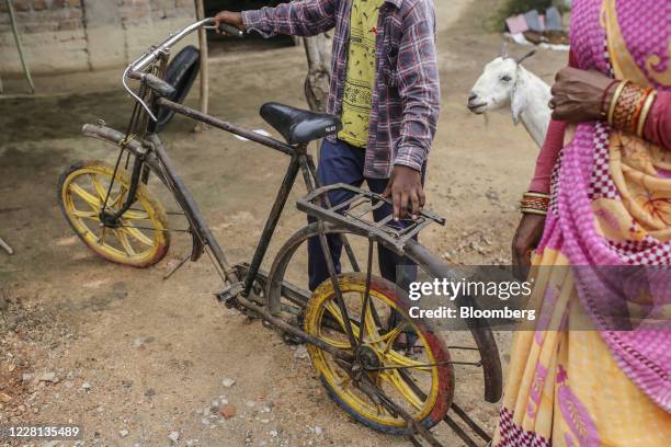 Boy holds a bicycle in a village in Tikamgarh district, Madhya Pradesh, India, on Friday, Aug. 7, 2020. Millions of migrant workers made arduous...