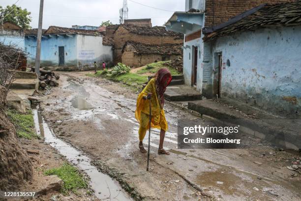 Woman using a cane walks through a village in Tikamgarh district, Madhya Pradesh, India, on Friday, Aug. 7, 2020. Millions of migrant workers made...