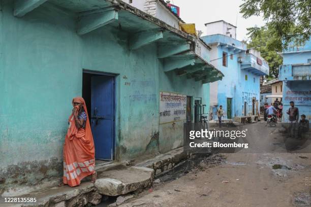 Woman stands outside a house at a village in Tikamgarh district, Madhya Pradesh, India, on Friday, Aug. 7, 2020. Millions of migrant workers made...