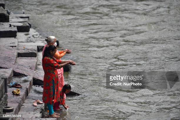 Nepalese devotees offer ritual prayer in the Bank of Bagmati River during Teej festival celebrations at Kathmandu, Nepal on Friday, August 21, 2020....