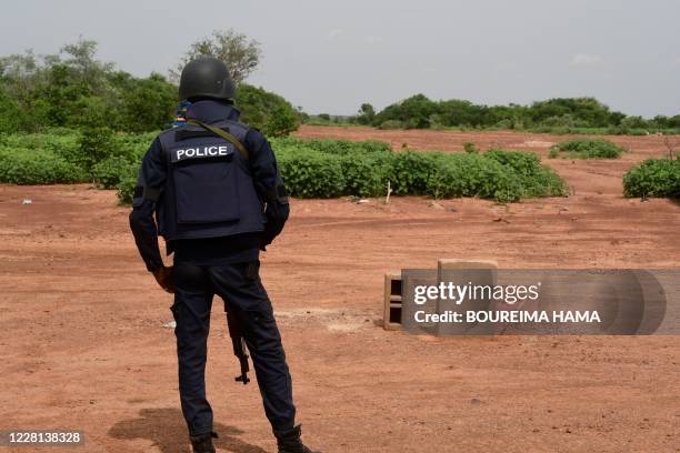 Nigerien police officer stands guard in the Kouré Reserve, about 60 km from Niamey on August 21 at the scene where six French aid workers, their...