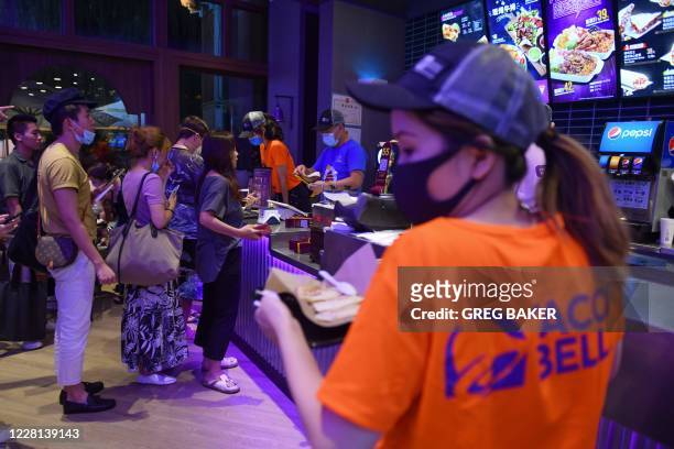 People line up to order food at a newly-opened Taco Bell restaurant in Beijing on August 21, 2020. - The US Tex-Mex fast food chain opened its first...