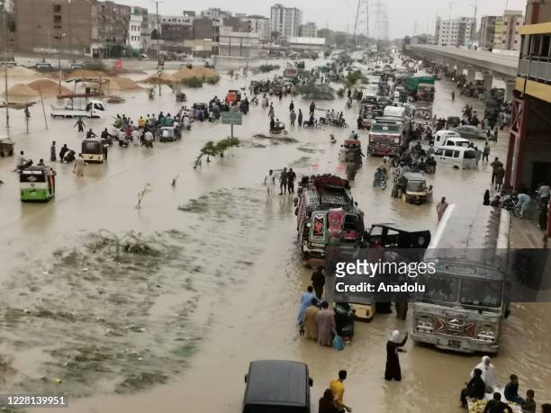People make their way through a flooded road after heavy rains in Karachi on August 21, 2020.