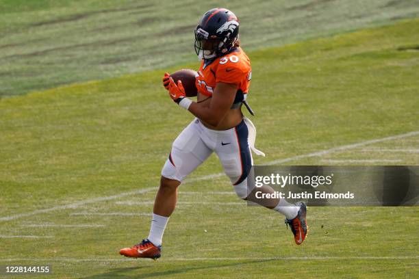 Running back Phillip Lindsay of the Denver Broncos runs with the football during a training session at UCHealth Training Center on August 21, 2020 in...