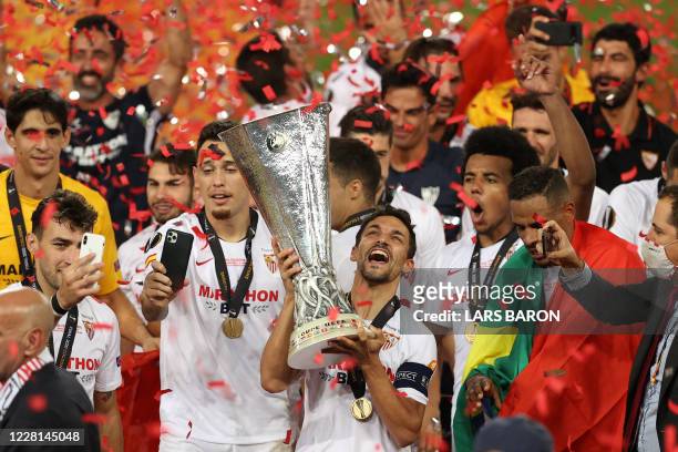 Sevilla's Spanish midfielder Jesus Navas holds the trophy as Sevilla's players celebrate after winning the UEFA Europa League final football match...