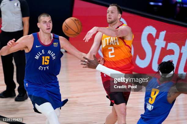 Utah Jazz's Joe Ingles dishes off as Denver Nuggets' Nikola Jokic defends during the second half of an NBA basketball first round playoff game at...