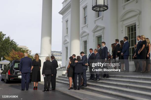 President Donald Trump, left, and First Lady Melania Trump, joined by members of the Trump family, look on as Robert Trumps casket is loaded into a...