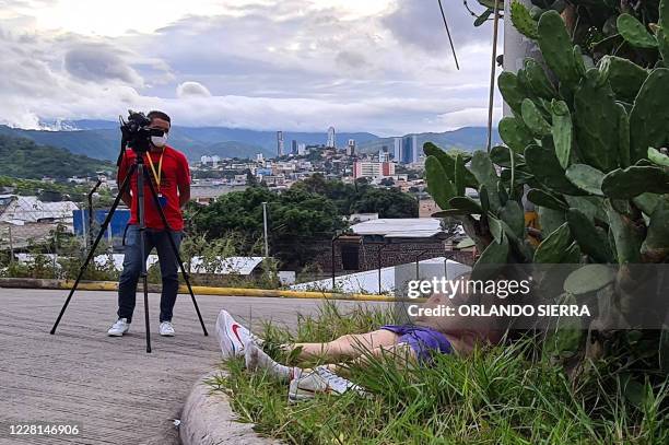 Graphic content / A cameraman looks at the corpse of a leader of the Barrio-18 street gang in a street in Tegucigalpa, on July 29, 2020. - Corpses...