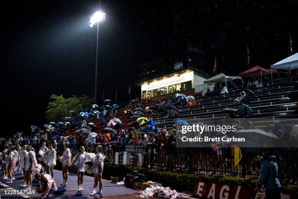 Fans, most wearing masks, watch the action from under umbrellas as Lipscomb Academy plays football against Brentwood Academy on August 21, 2020 in...