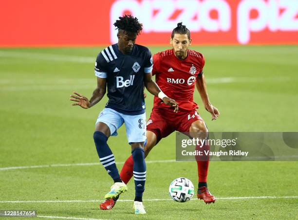 Tosaint Ricketts of Vancouver Whitecaps FC battles for the ball with Omar González of Toronto FC during the second half of an MLS game at BMO Field...