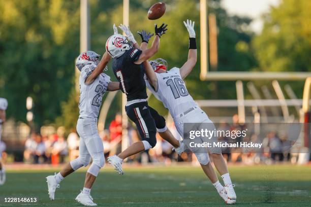 Caleb Koeppen of the Lafayette Jefferson Broncos goes up for a pass against Cannon Melchi and Sam Schott of the West Lafayette Red Devils at...