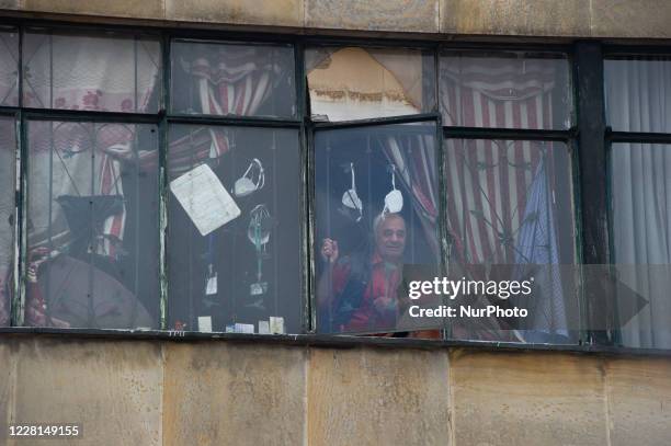 Men sees the street from his window with hanging face masks during the sectorized lockdowns, on August 21 in Bogota, Colombia.